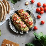 Avocado toast with feta cheese, cherry tomatoes and microgreens on toasted sourdough bread