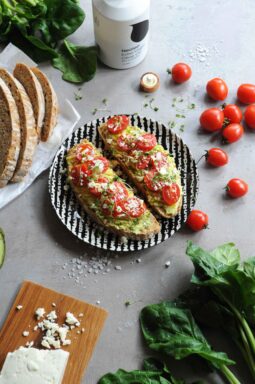 Avocado toast with feta cheese, cherry tomatoes and microgreens on toasted sourdough bread