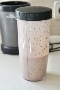 Blended protein chia pudding mixture with coconut milk in a blender cup