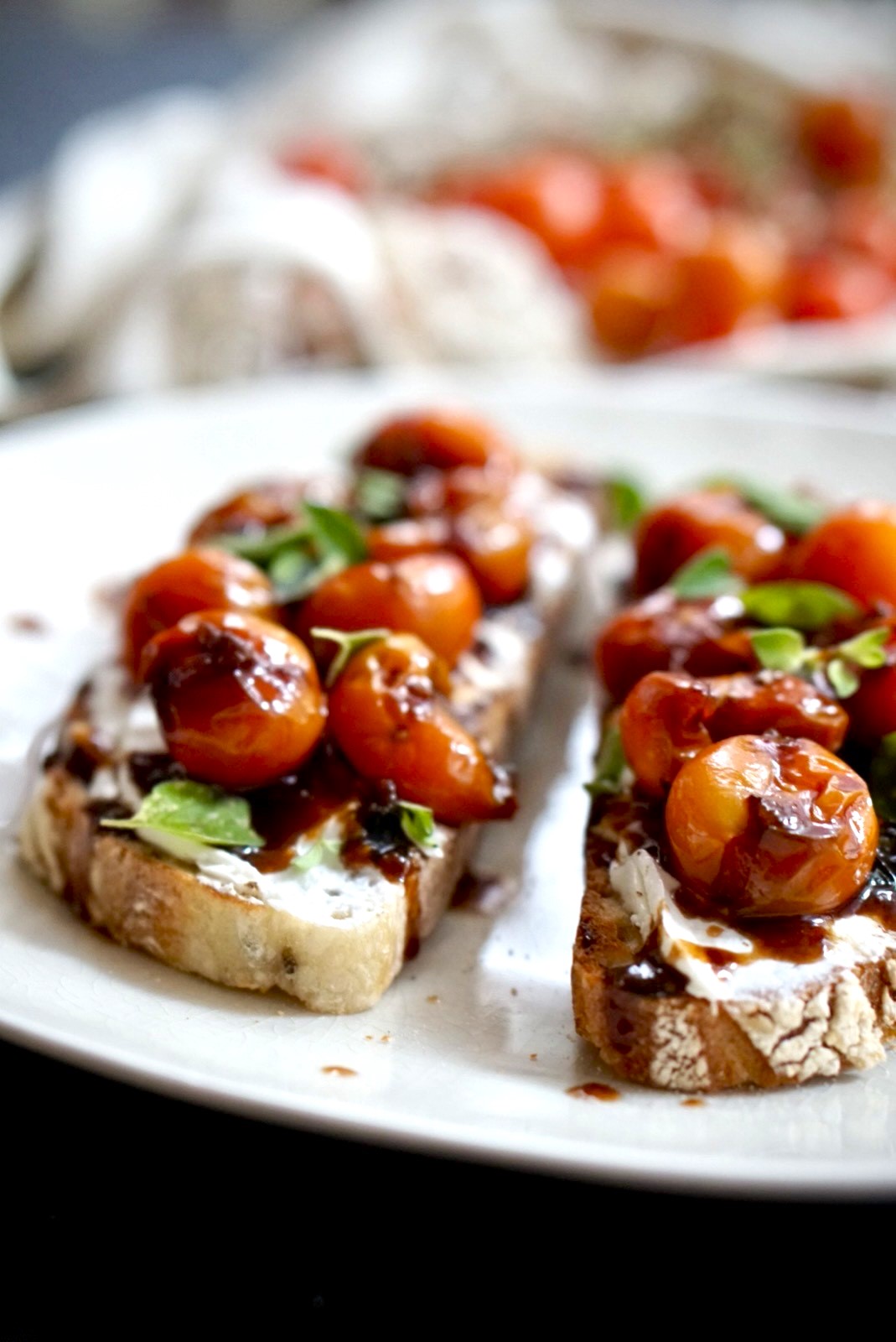Ricotta toast topped with burst cherry tomatoes and balsamic glaze