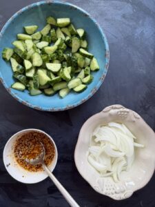 Prepared cucumbers, sliced onions, and homemade dressing for Korean Cucumber Salad (Oi Muchim).