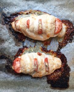 Baked Hasselback chicken breasts stuffed with melted mozzarella, fresh tomatoes, and basil in a baking dish