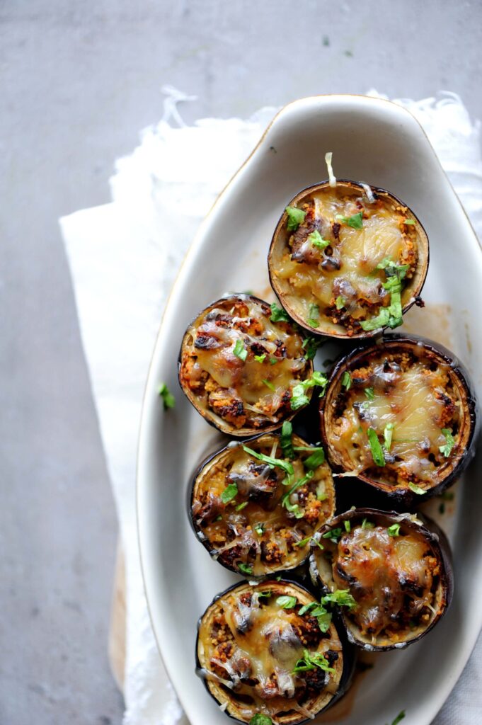 Baked eggplant cups filled with seasoned ground beef and topped with melted Gouda