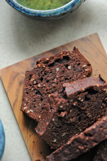 Close-up shot of rich chocolate almond loaf cake slices arranged on a wooden board