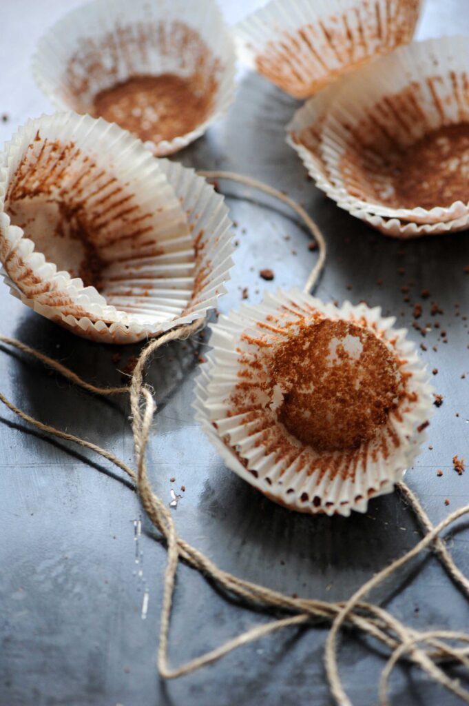 Empty chocolate muffin liners with crumbs after serving