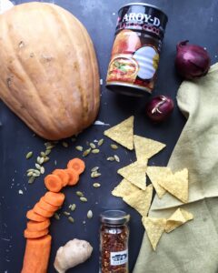 Ingredients for creamy pumpkin soup: cubed pumpkin, full-fat coconut milk, red onions, carrot, and fresh ginger