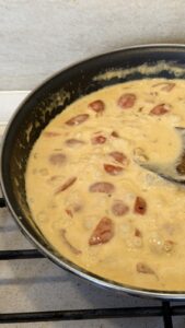 Creamy tomato sauce simmering in a skillet with visible tomato chunks