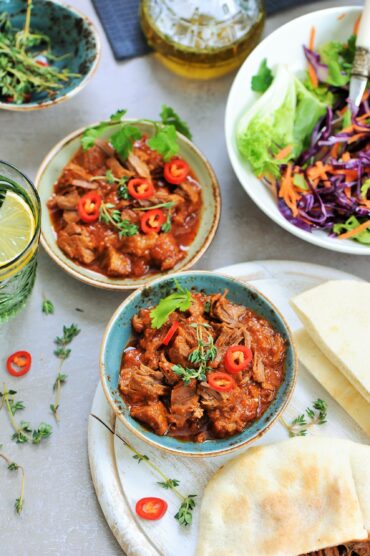 Dutch oven braised beef in rich tomato sauce served in two bowls