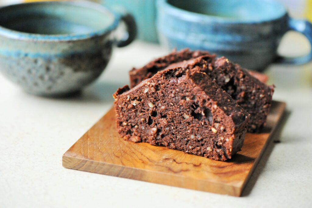 Slices of homemade chocolate almond loaf cake on a wooden board