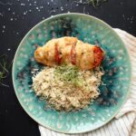 Plated Hasselback chicken breast with mozzarella and tomatoes served alongside a mix of basmati and wild rice