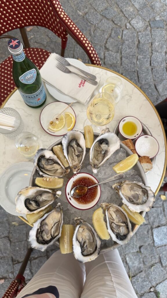 Oyster platter on ice served with mignonette, lemon, and white wine