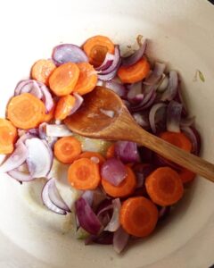 Sautéed carrots and red onions cooking in a pot