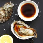 Fresh oyster served with soy sauce, lemon juice, and olive oil