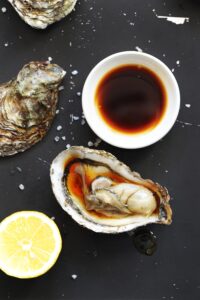 Fresh oyster served with soy sauce, lemon juice, and olive oil