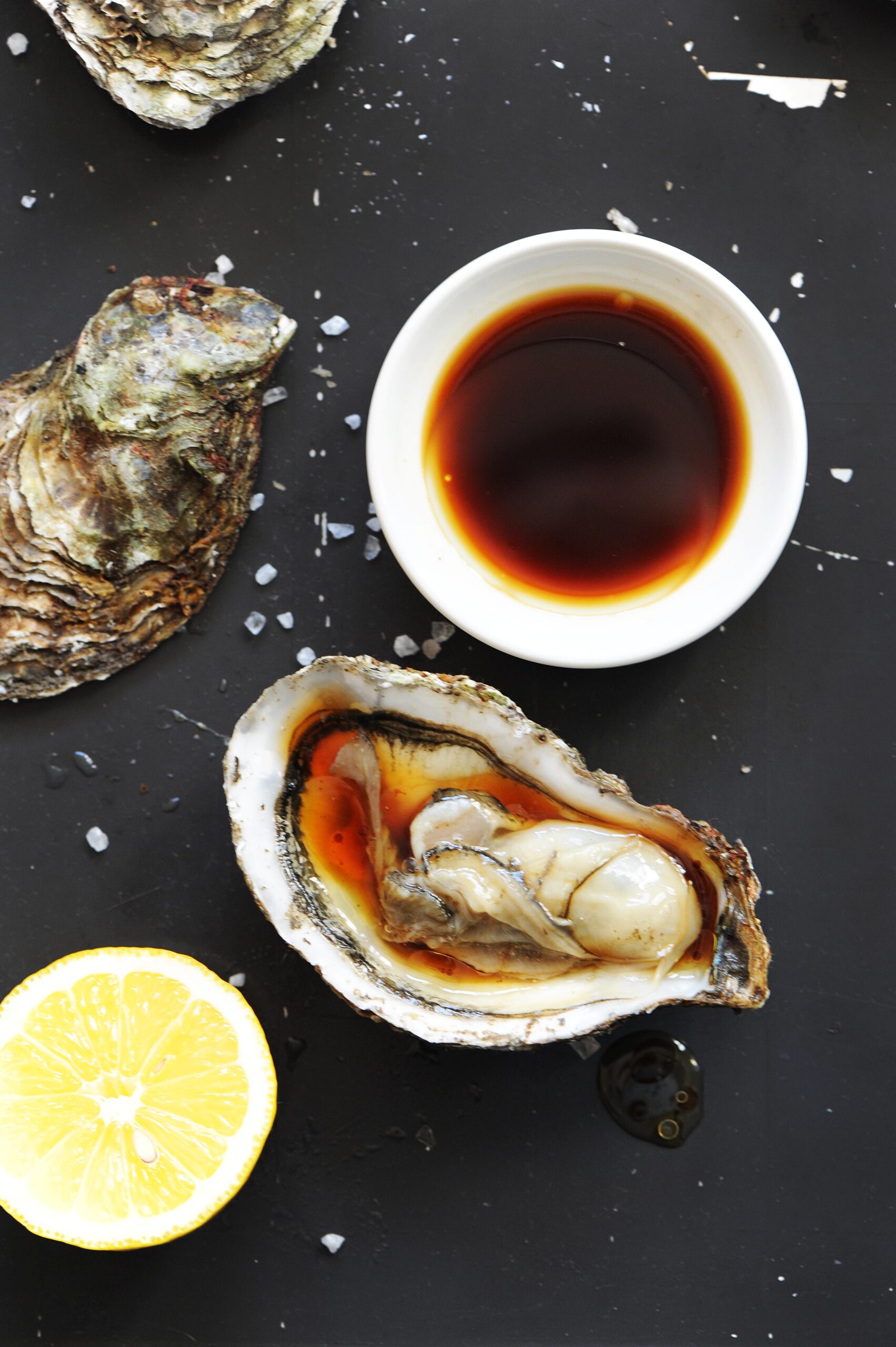 Fresh oyster served with soy sauce, lemon juice, and olive oil