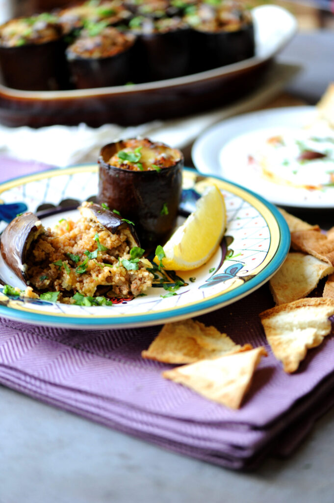 Stuffed eggplant with ground beef served with yogurt, lemon, and crispy pita wedges
