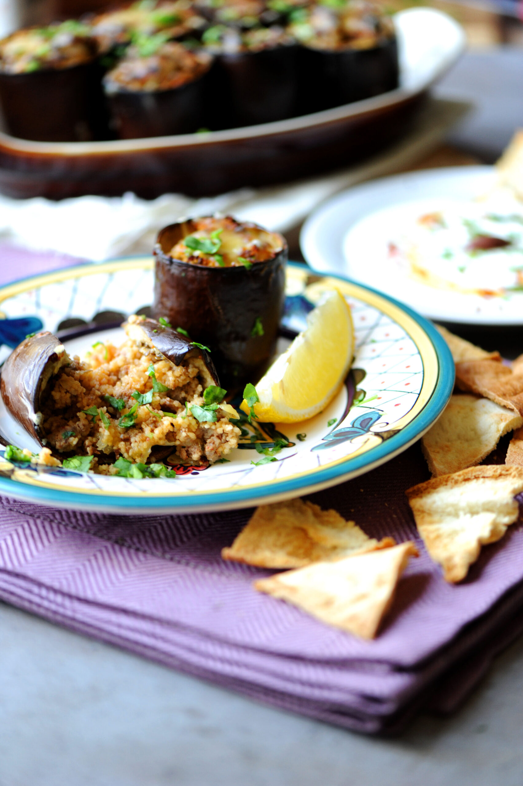 Stuffed eggplant with ground beef served with yogurt, lemon, and crispy pita wedges