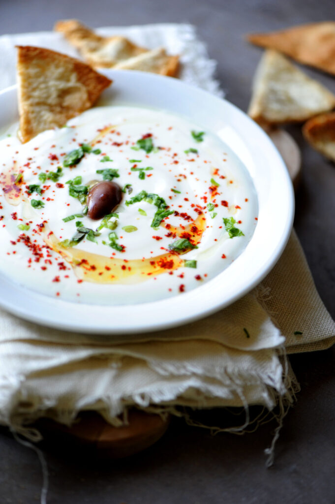 Plain yogurt with olive oil, paprika, parsley, and Kalamata olive served with pita