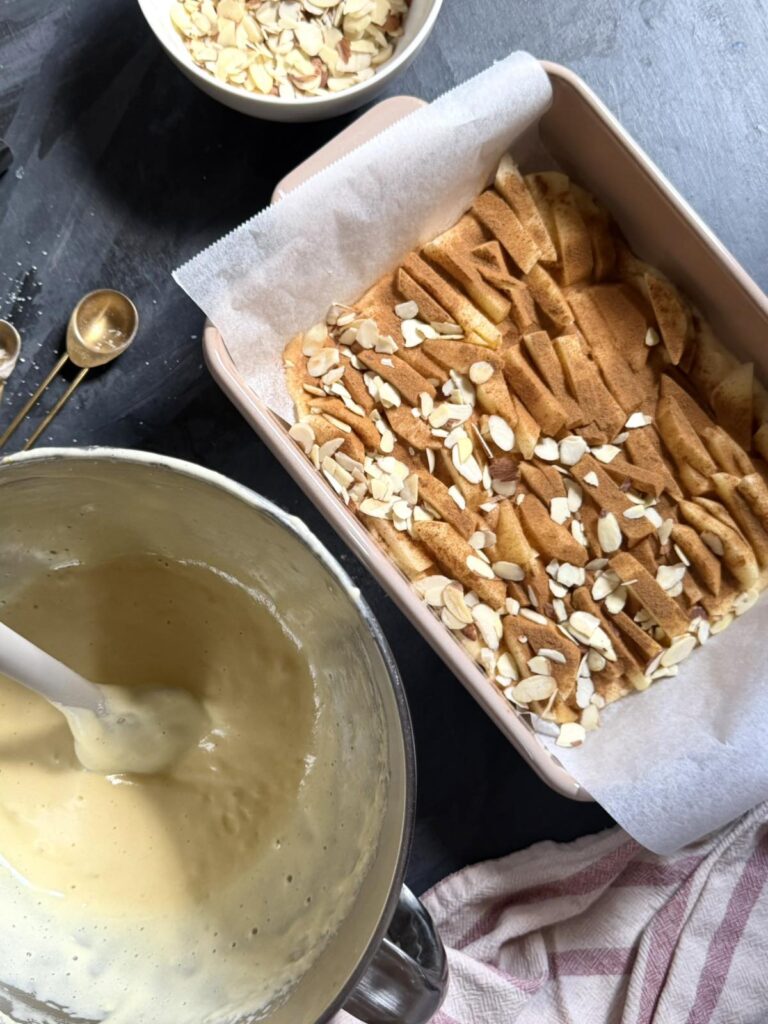 Unbaked apple charlotte cake layered with apples and almonds, ready for the oven