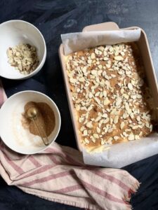 Baked apple charlotte cake topped with sliced almonds in a ceramic baking dish