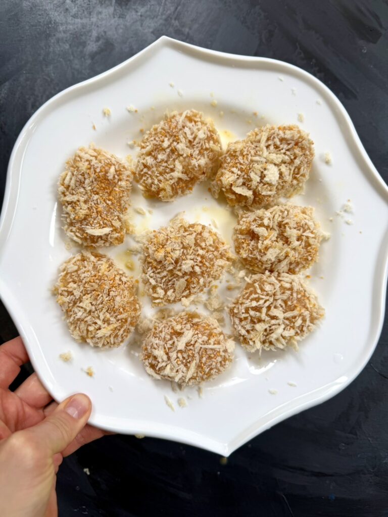 A plate of fully breaded ground chicken nuggets ready for the skillet.