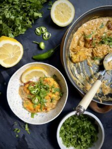 Coconut milk chicken with Tom Yum paste served over rice beside the skillet.