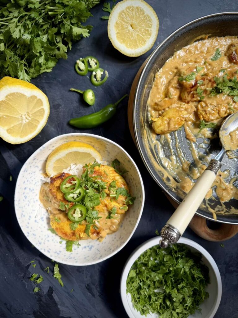 Coconut milk chicken with Tom Yum paste served over rice beside the skillet.