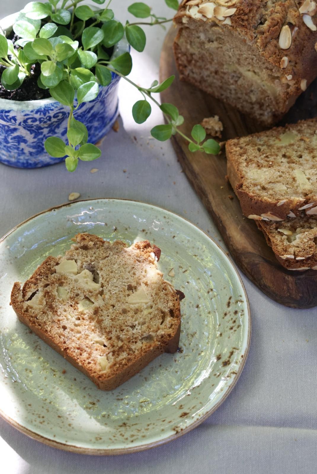Homemade apple bread loaf served with fresh apples and tea