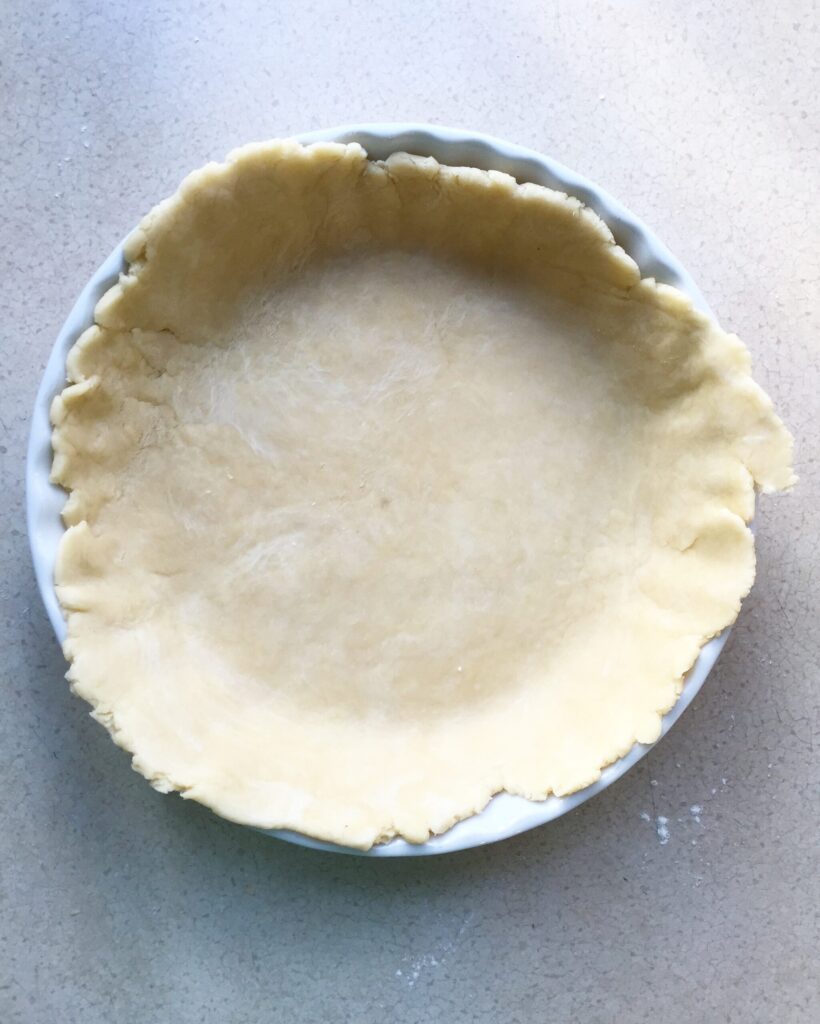 Homemade shortcrust pastry crimped into a pie dish for quiche